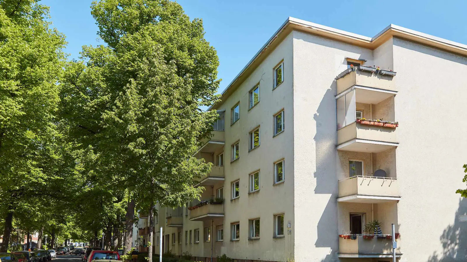 Unsaniertes Mehrfamilienhaus aus den Nachkriegsjahren mit verwitterter Putzfassade und alten Balkonen — auch solche Objekte kauft Papakaufthaus.de an