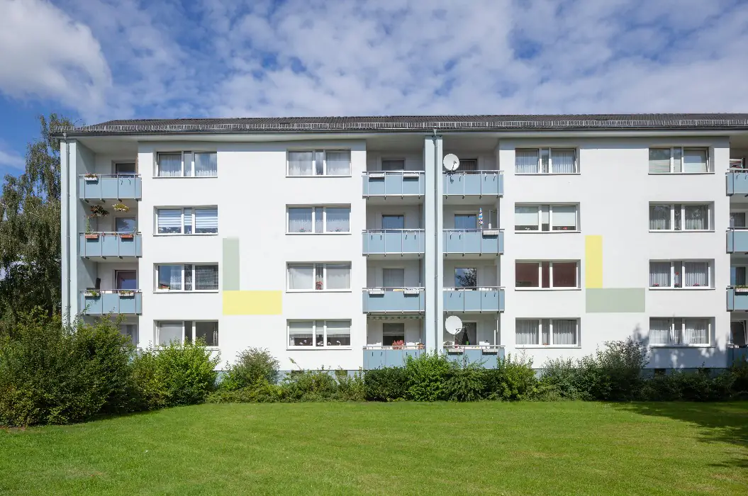 Vermietetes Mehrfamilienhaus mit mehreren Etagen und Balkonen — ein Haus, dessen Betrieb heute laufend Pflichten auslöst