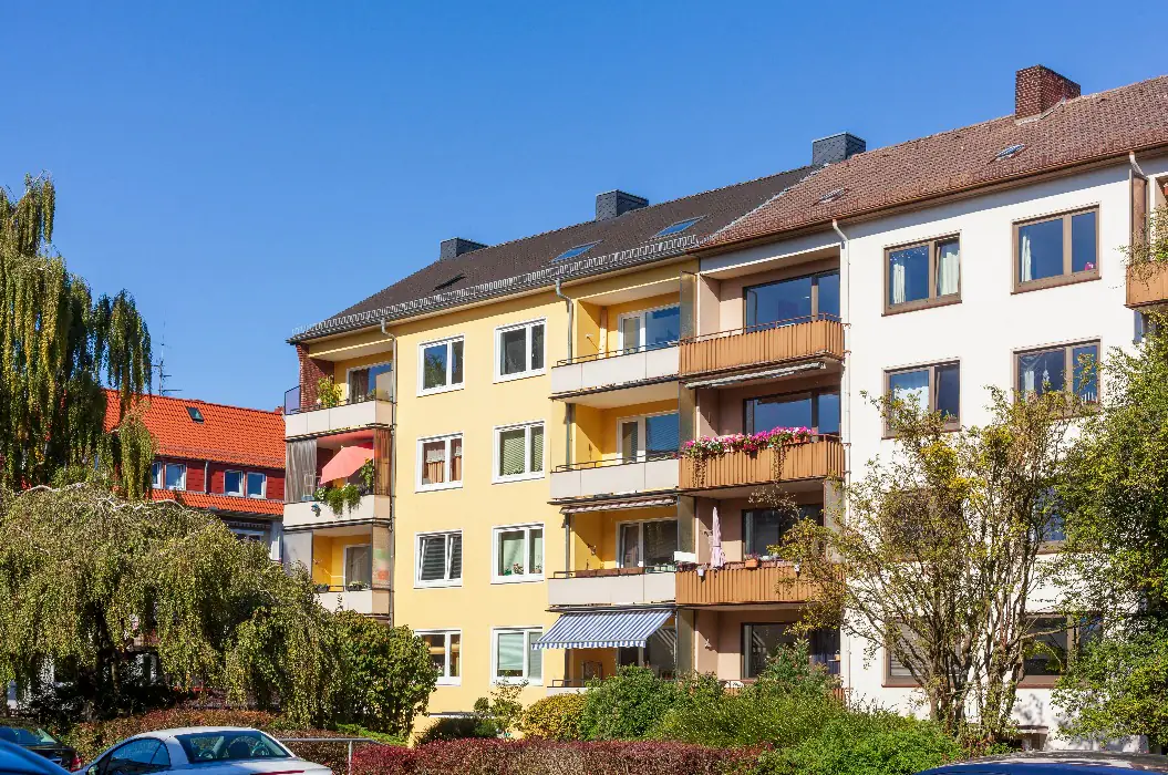 Mehrfamilienhaus mit Balkonen und Bäumen — ein dauerhaft vermietetes Bestandsobjekt, wie wir es im Bodenseekreis gezielt ankaufen